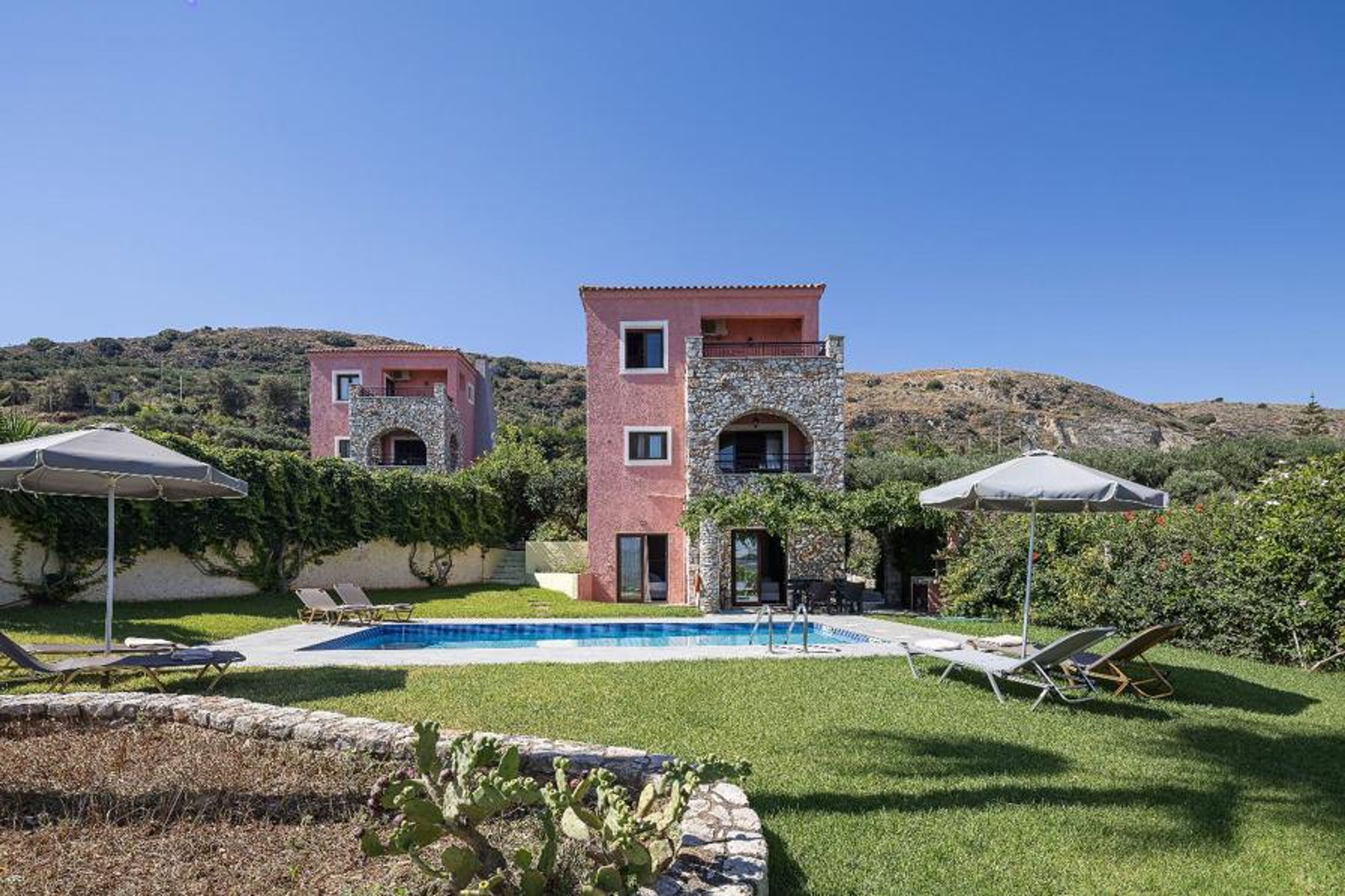 A wide, straight-on exterior view of the vacation property, showcasing the layout of the villas and the shared central recreation space.