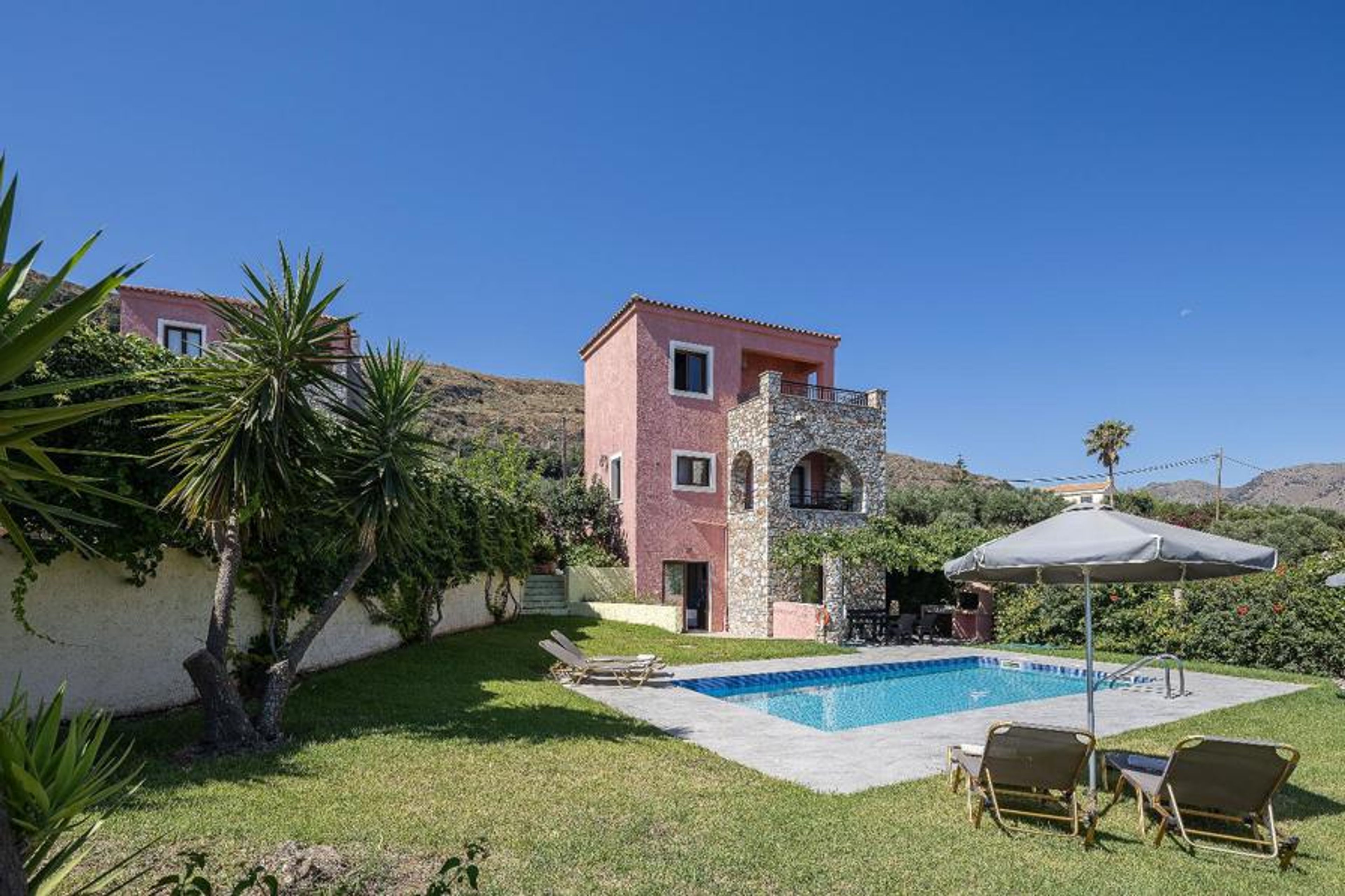 This image captures the exterior of a beautiful, multi-level Mediterranean vacation villa.