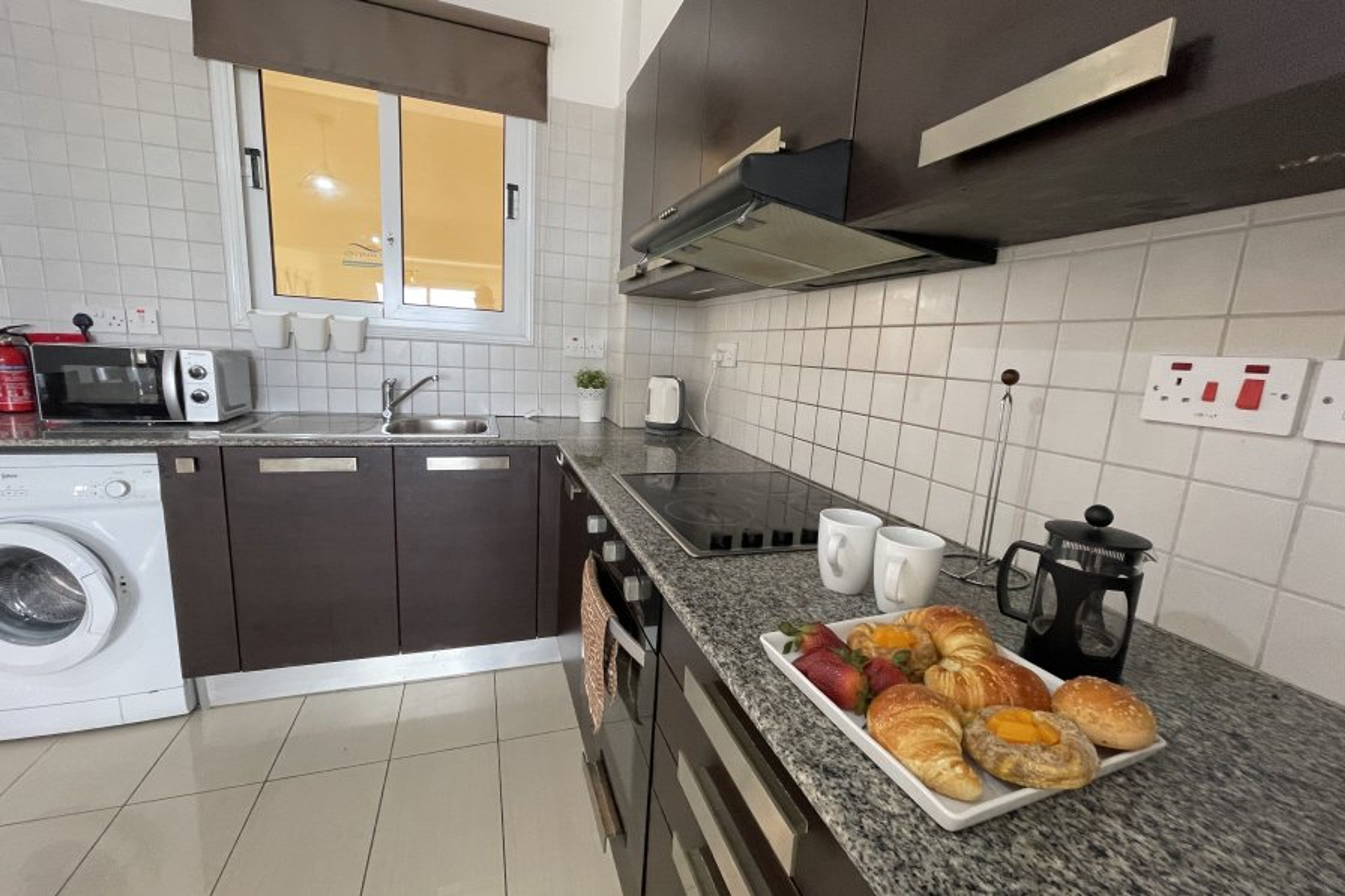 Full kitchen with washing machine.