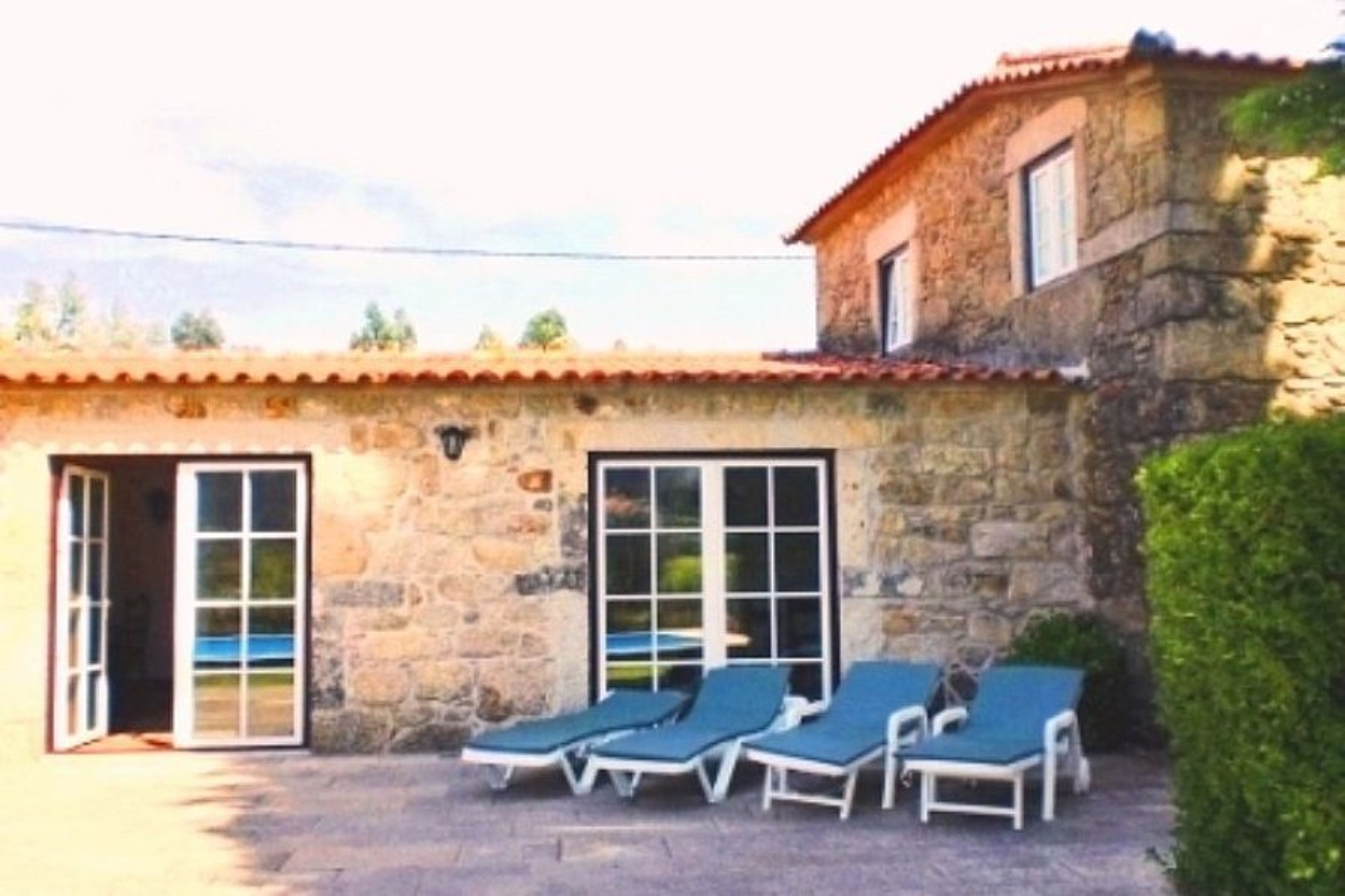 The large living room with glass windows and doors looking out onto the patio and swimming pool